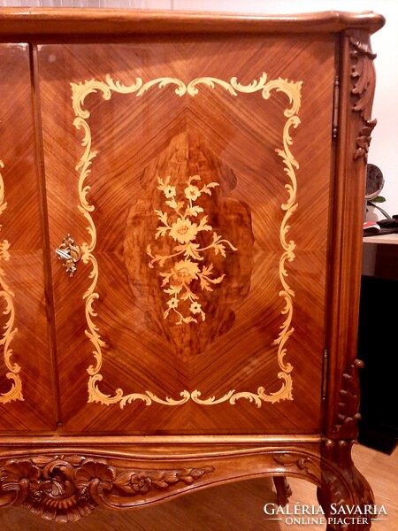 A wonderful baroque high-legged chest of drawers decorated with hand-carvings and hand-inlays, marked piece