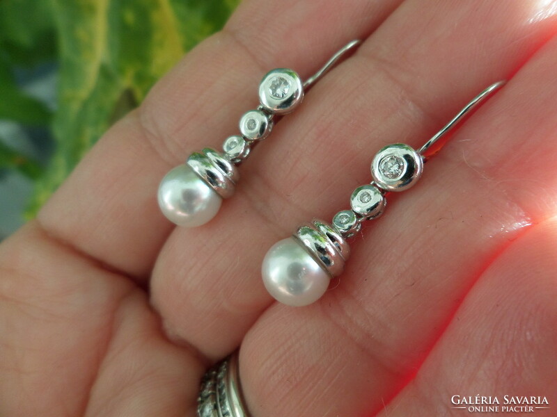 A pair of white gold earrings with akoya pearls and glasses