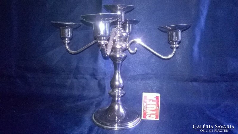 Silver-colored, five-pronged metal candle holder