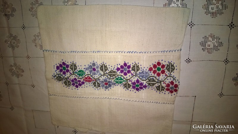 Traditional decorative pillow on home linen with cross-stitch needlework, a beautiful piece.