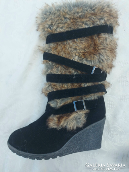 Women's warm boots with raised soles, decorated with fur and straps.