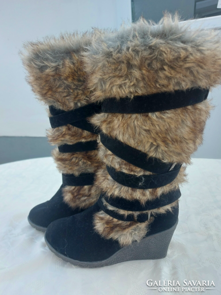 Women's warm boots with raised soles, decorated with fur and straps.