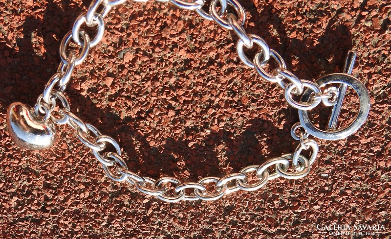 A silver heart with stones on a bracelet