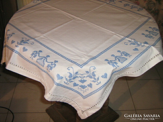 Beautiful hand embroidered azure blue motif on white tablecloth