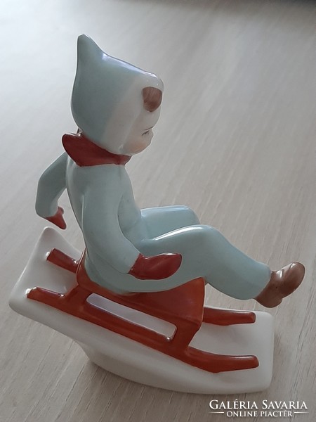 A sledding child based on Aquicum's hand-painted porcelain cooper Aurél's design