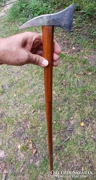 A walking stick with a step-like iron handle head.