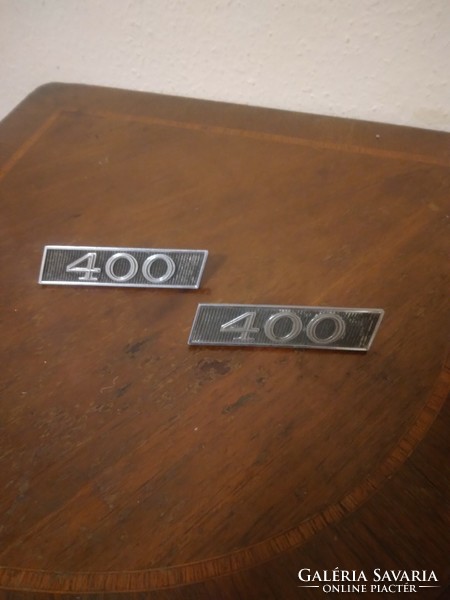 A pair of American car emblems from the sixties, indicating a 400 cu in v8 as engine, type unknown, ...