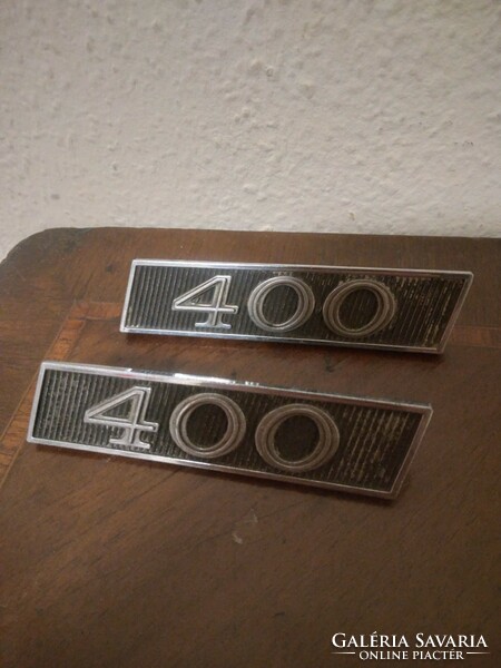 A pair of American car emblems from the sixties, indicating a 400 cu in v8 as engine, type unknown, ...