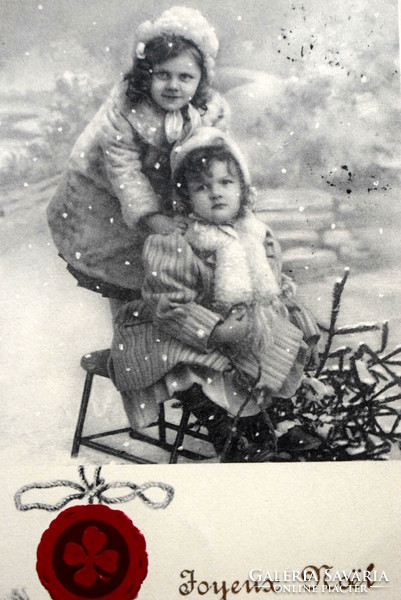 Antique Christmas greeting photo postcard - little girls sledding, pine, embossed seal 4-leaf clover