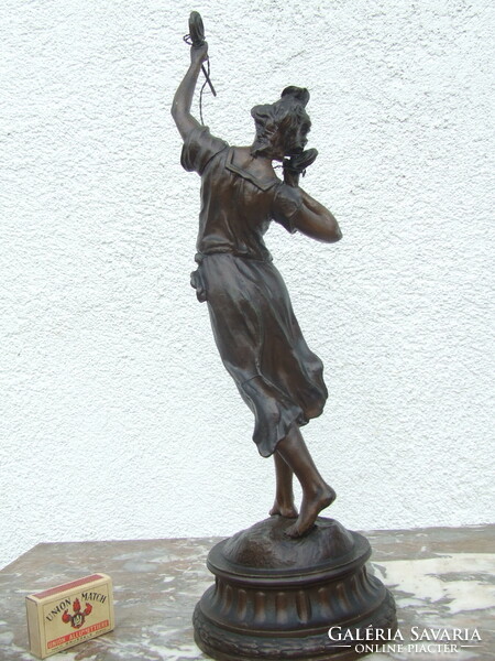 A spaiater statue of a woman examining electricity