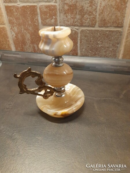 Candle holder made of decorative stone. With a copper-colored ear. Candle holder with spike