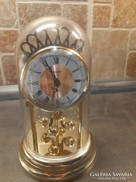 Staiger quartz clock rotating pendulum, gold colored clock. It works