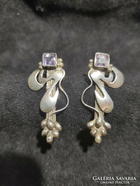 Non-figurative silver earrings with a purple stone