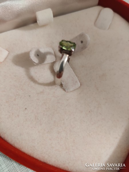 Silver ring with green stones in claw socket