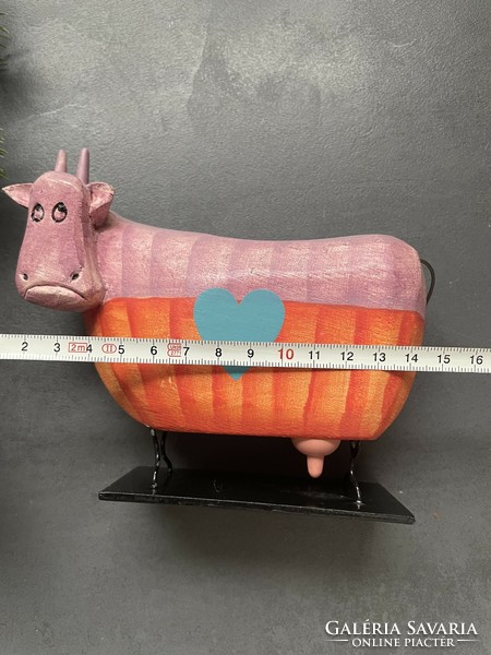 Colorful wooden cow on a metal base