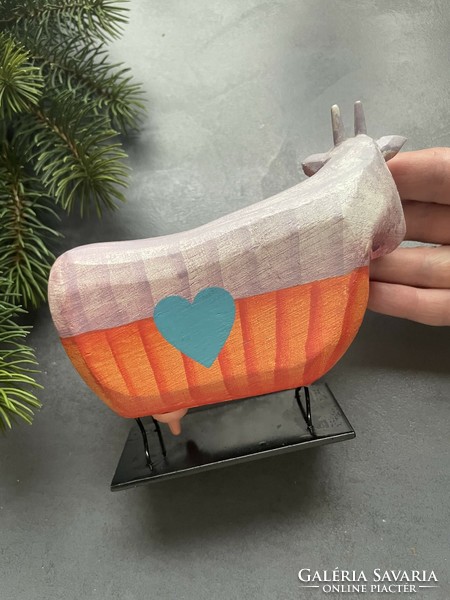 Colorful wooden cow on a metal base