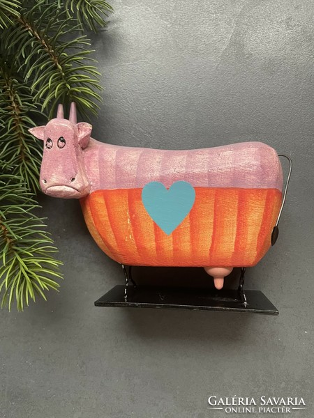 Colorful wooden cow on a metal base