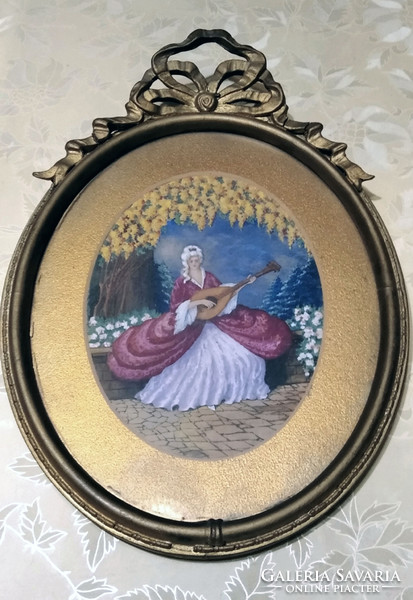 A pair of rococo pictures in an oval picture frame with a bow