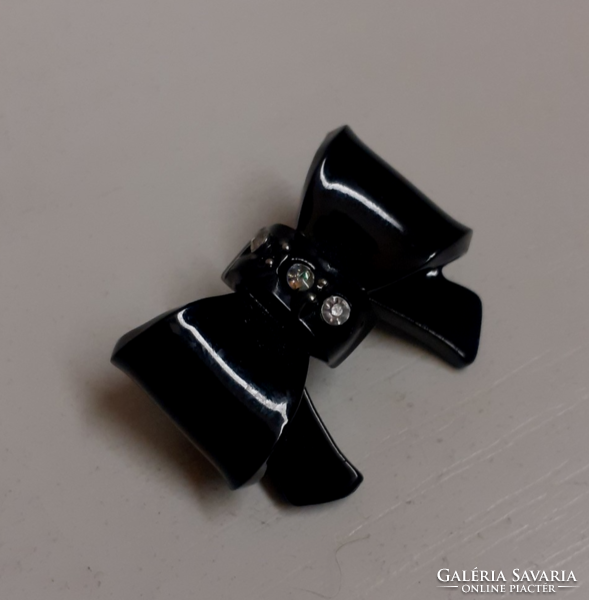 A black bow-shaped brooch in nice condition, studded with tiny white sparkling stones