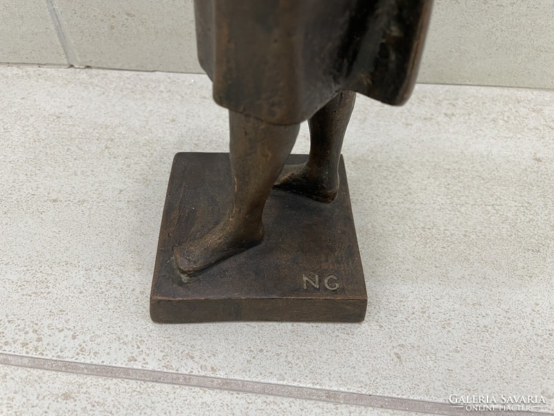 Resin statue of a female figure with a sign
