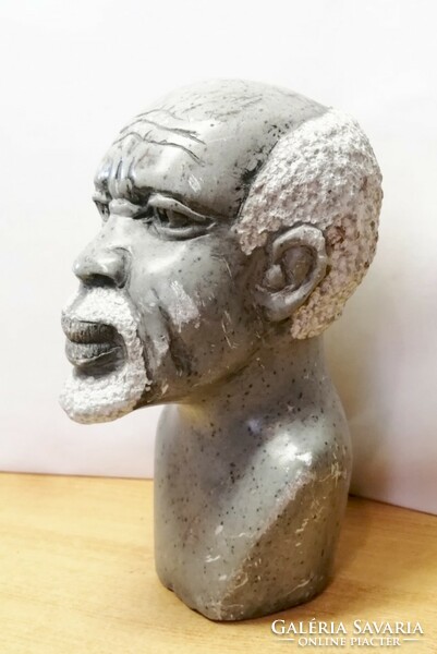 Gray granite African distorted statue. With a graying native figure