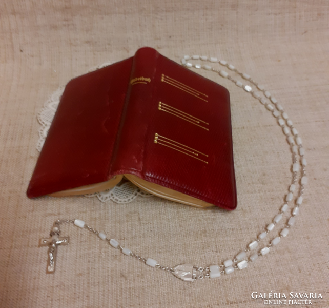 Old German language leather bound prayer book with gilt edges and mother of pearl rosary on lace tablecloth together