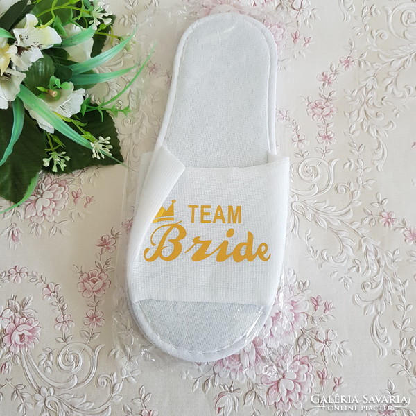 New, gold-colored slippers with the inscription team bride