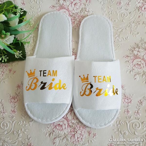 New, gold-colored slippers with the inscription team bride