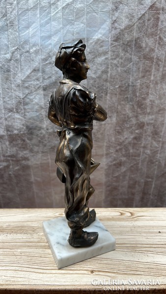 The statue of a metal worker on a marble slab is 33 cm high