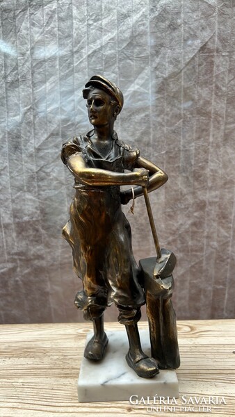The statue of a metal worker on a marble slab is 33 cm high