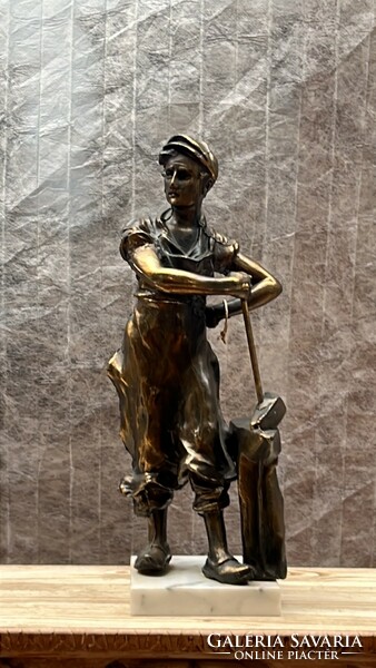The statue of a metal worker on a marble slab is 33 cm high