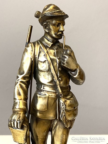 Antique metal statue of a pipe-smoking hunter and a retriever on a marble base