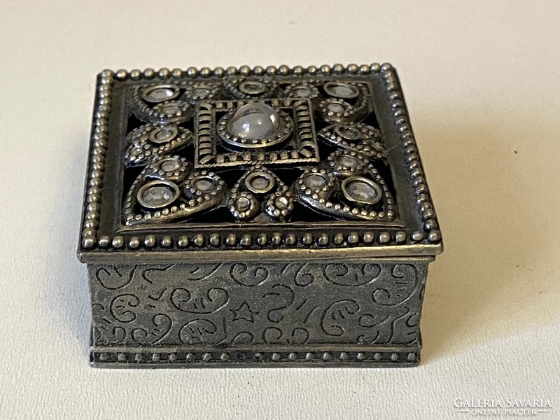 Metal jewelery box with a rectangular lid and openwork decoration