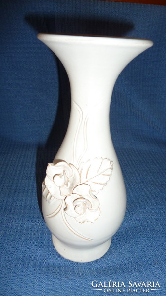 Slender white ceramic vase with raised rose