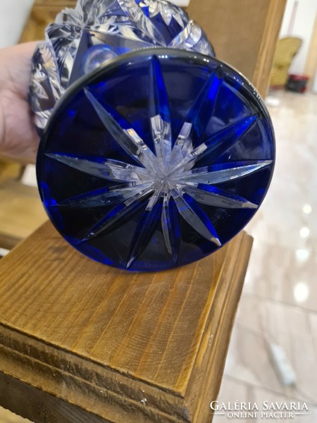 A polished blue old glass vase with a silver rim