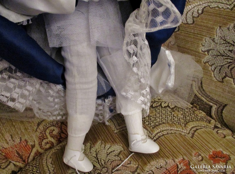 Old doll with big porcelain head in nice clothes