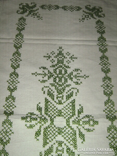 Woven tablecloth runner with a lace edge embroidered with a beautiful green pattern