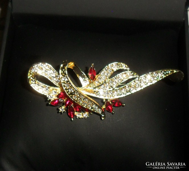 Beautiful, gold-colored brooch decorated with red stones and zirconia. More beautiful than in the pictures!