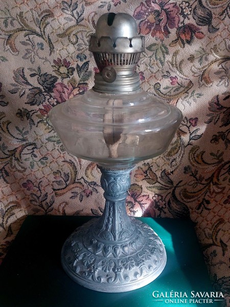 A petroleum lamp with a metal base and a milk glass lamp together.