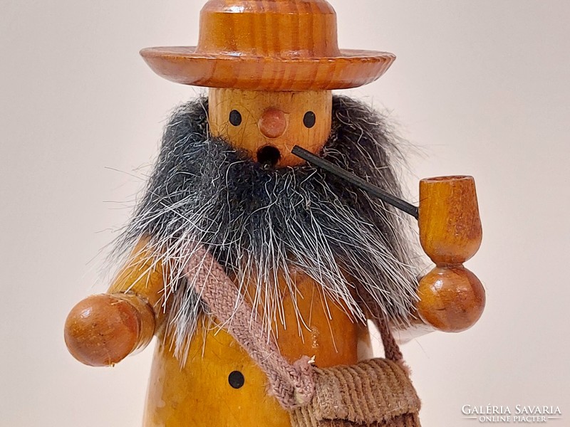 Smoking wooden figure bearded man