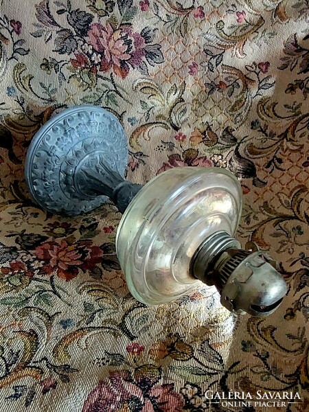 A petroleum lamp with a metal base and a milk glass lamp together.