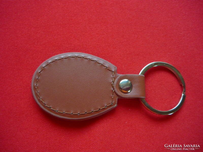 Iseki metal keychain on a leather background
