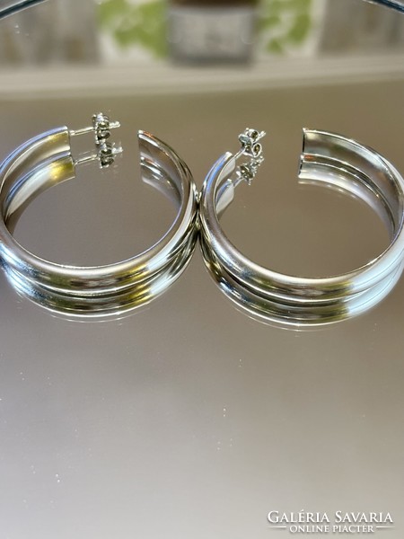 A pair of larger silver hoop earrings with a clean shape