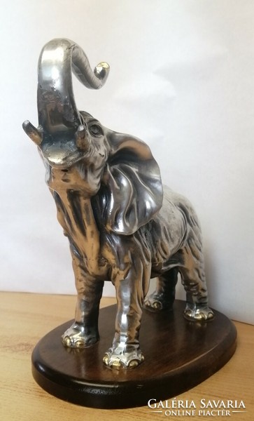 Silver-plated pewter elephant statue with raised trunk, on a wooden plinth