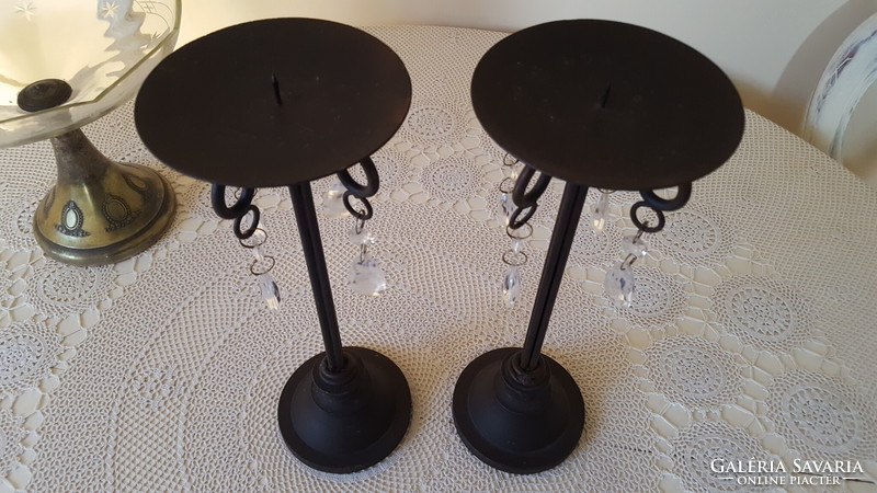 A pair of wrought iron candle holders with crystal glass pendants