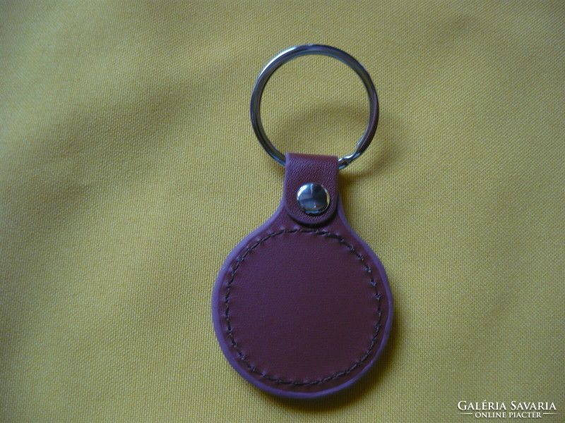 Suzuki metal keychain on a leather background