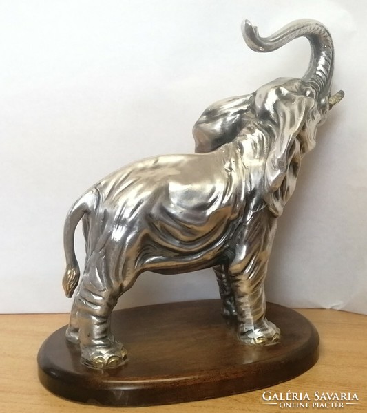 Silver-plated pewter elephant statue with raised trunk, on a wooden plinth