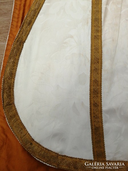 White brocade vestment trimmed with gold, metallic thread trim. Liturgical, priestly dress