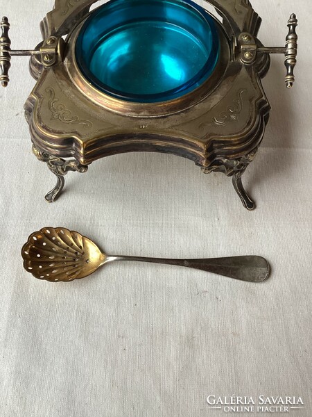 Silver-plated caviar offering with blue glass insert and spoon.