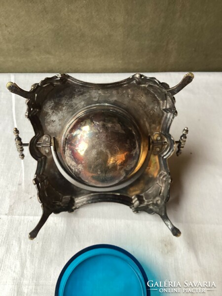 Silver-plated caviar offering with blue glass insert and spoon.